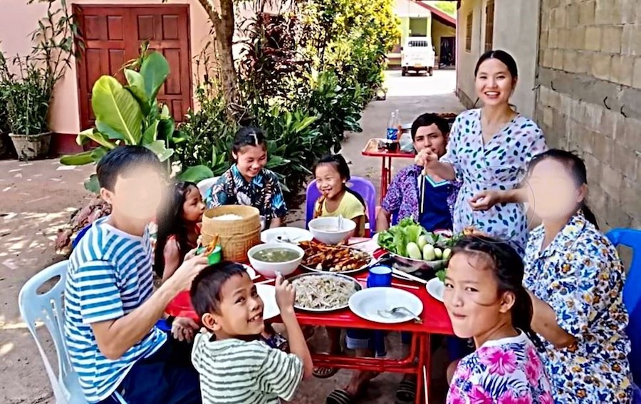 Family eating meal around an outside table