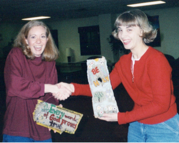 Heidi and Jenna hold their crafted wooden plaques 